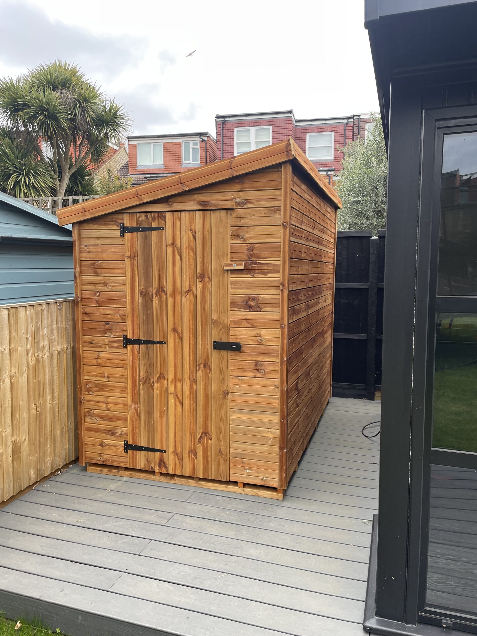 Pressure-treated wooden pent shed with single, suitable for compact garden storage.