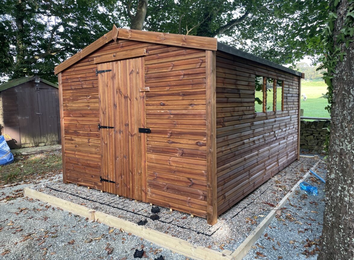 Pressure-treated wooden pent shed with single door and side window, suitable for compact garden storage.