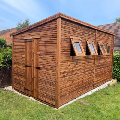 Timber garden shed shown from side angle, featuring shiplap cladding, felt roof, and opening windows.