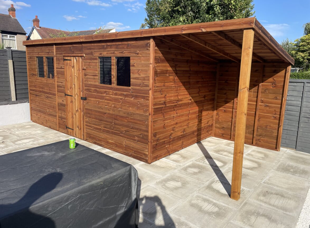 Pent garden shed with a open extension and 4 windows around the single door
