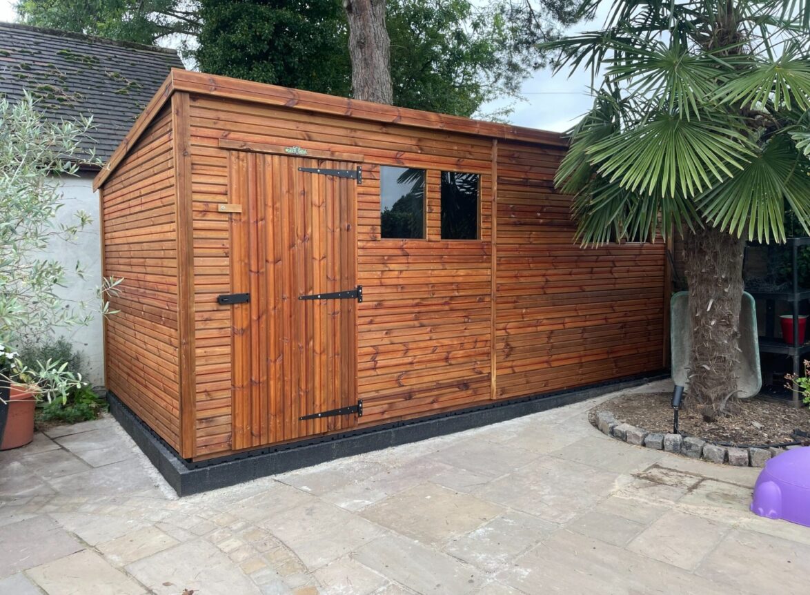 Side angle of a heavy duty pent garden shed with a single door and two windows