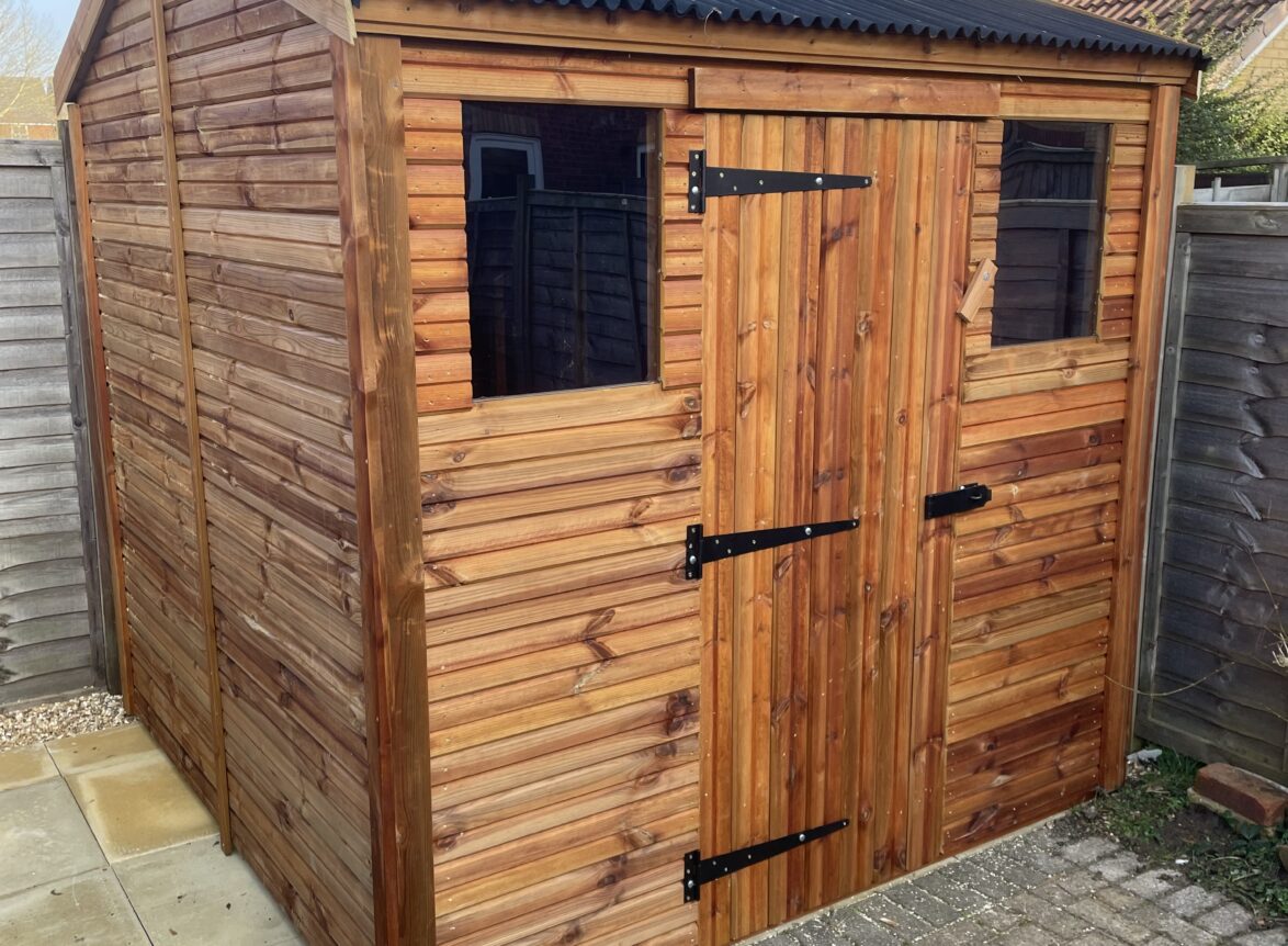 Small apex shed with onduline roofing and a single door