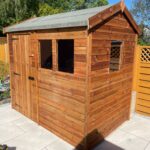 Small timber garden shed shown from side angle, featuring shiplap cladding, felt roof, and secure door hinges with 3 windows.